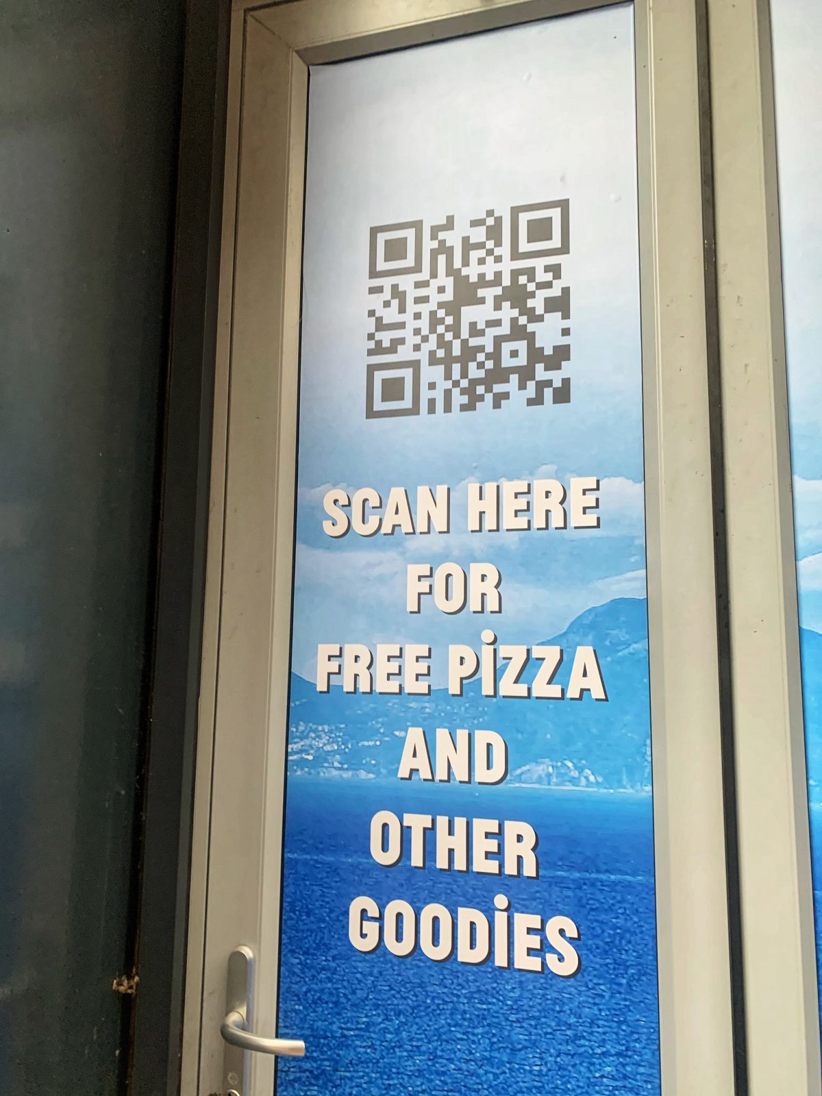 sign reads 'scan here for free pizza and other goodies' next to QR code.