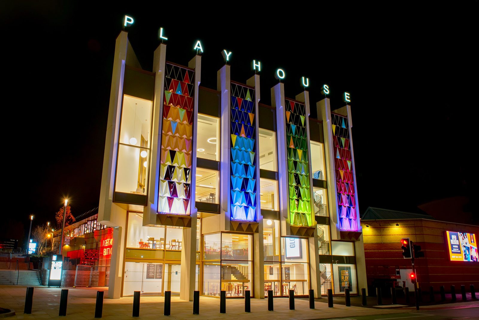 Outside of Leeds Playhouse building with rainbow coloured pillars and sign spelling 'playhouse' out.