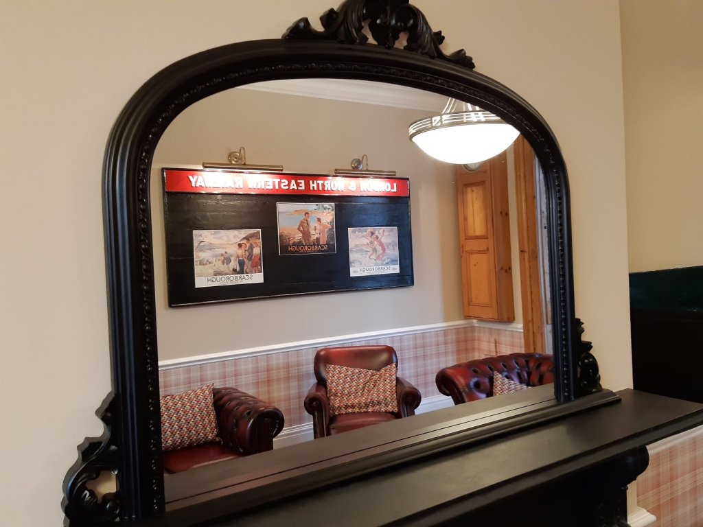 mirror reflecting view of leather sofas.