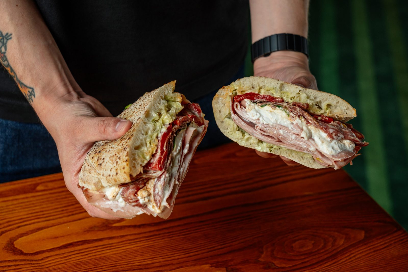 two pizza sandwiches held in two hands.