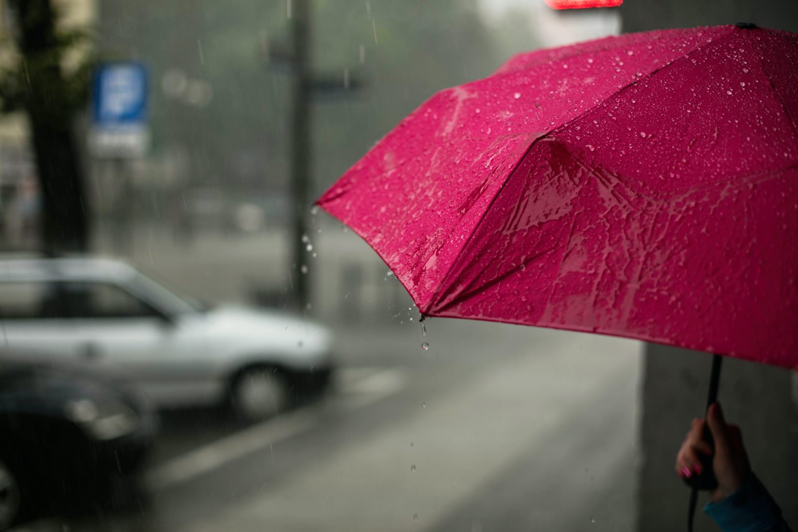 A woman holding an umbrella in a storm. 