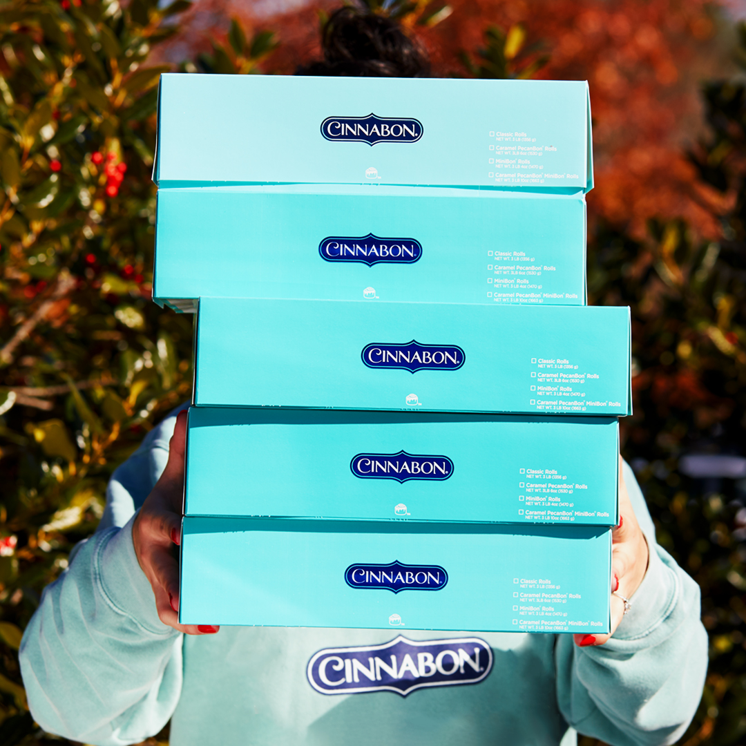 Boxes of cinnamon rolls from Cinnabon stacked on top of eachother. 