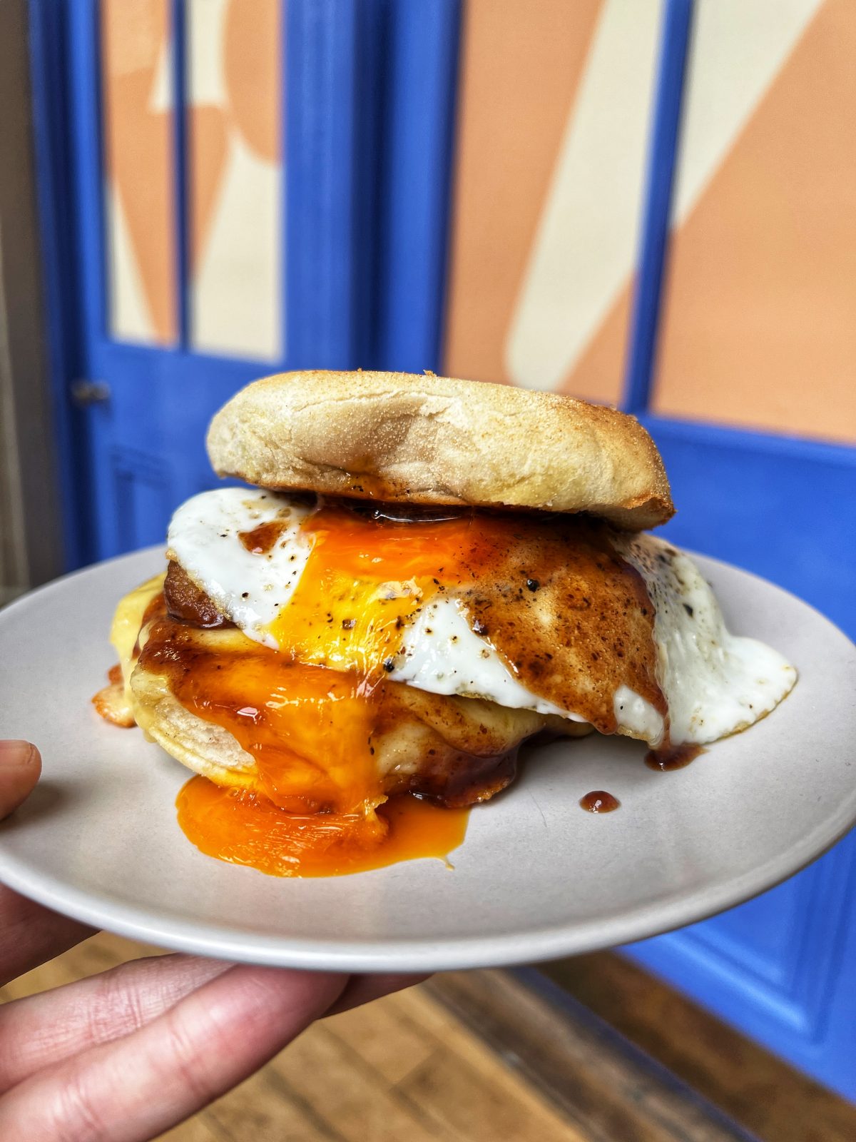 egg sandwich in a muffin behind a blue door.