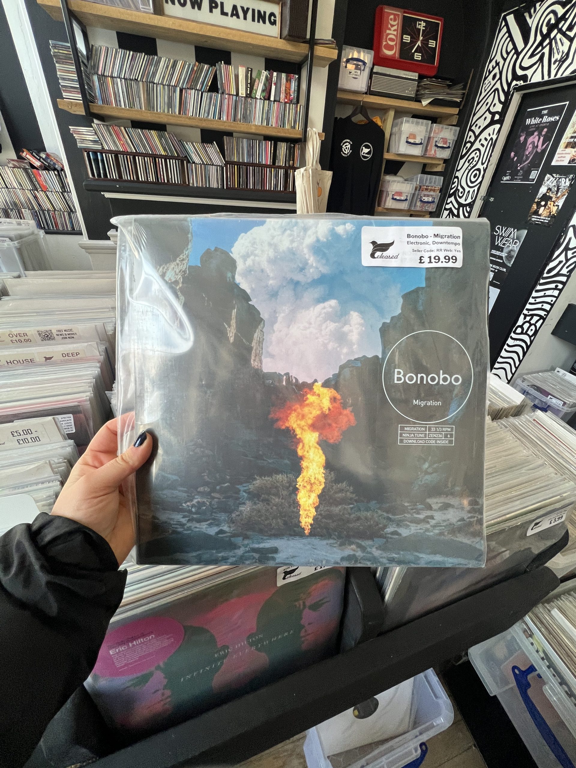 Bonobo record held up next to other records.