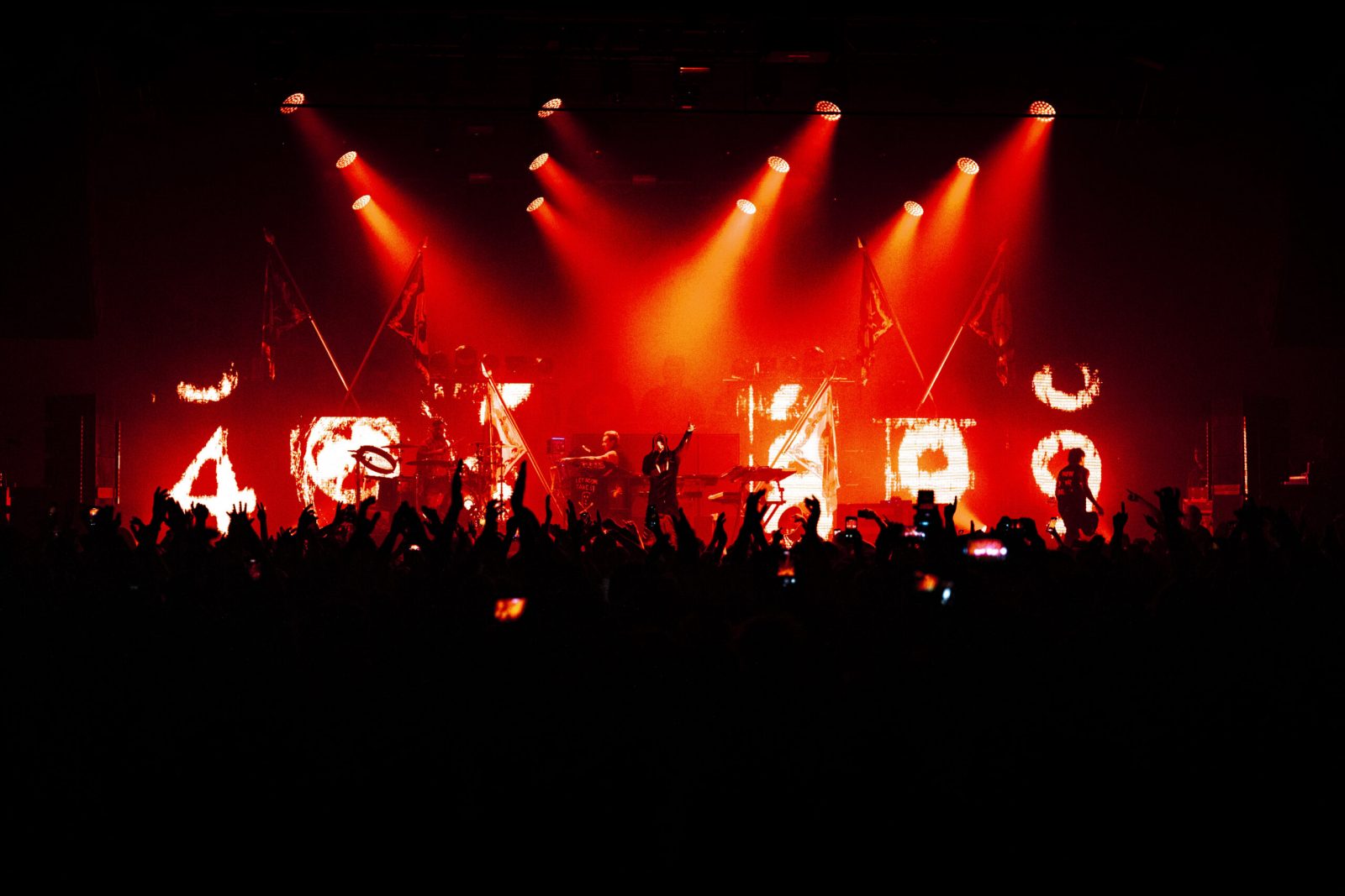 band performing with red lights in the background. 