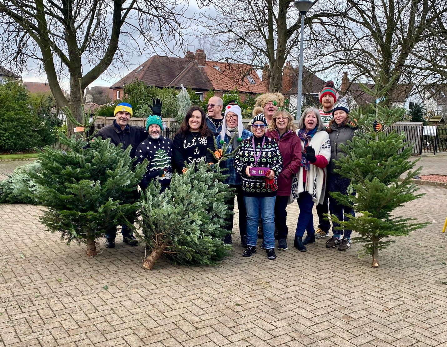 People holding up Christmas trees outside St Gemma's Hospice. 