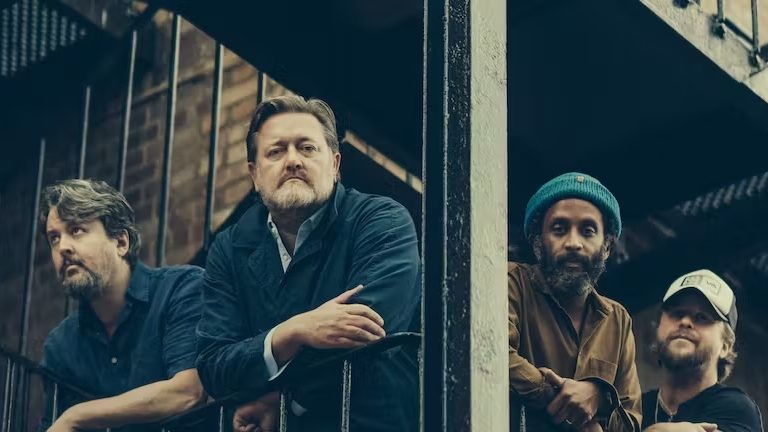 All members of Elbow looking over a bannister.