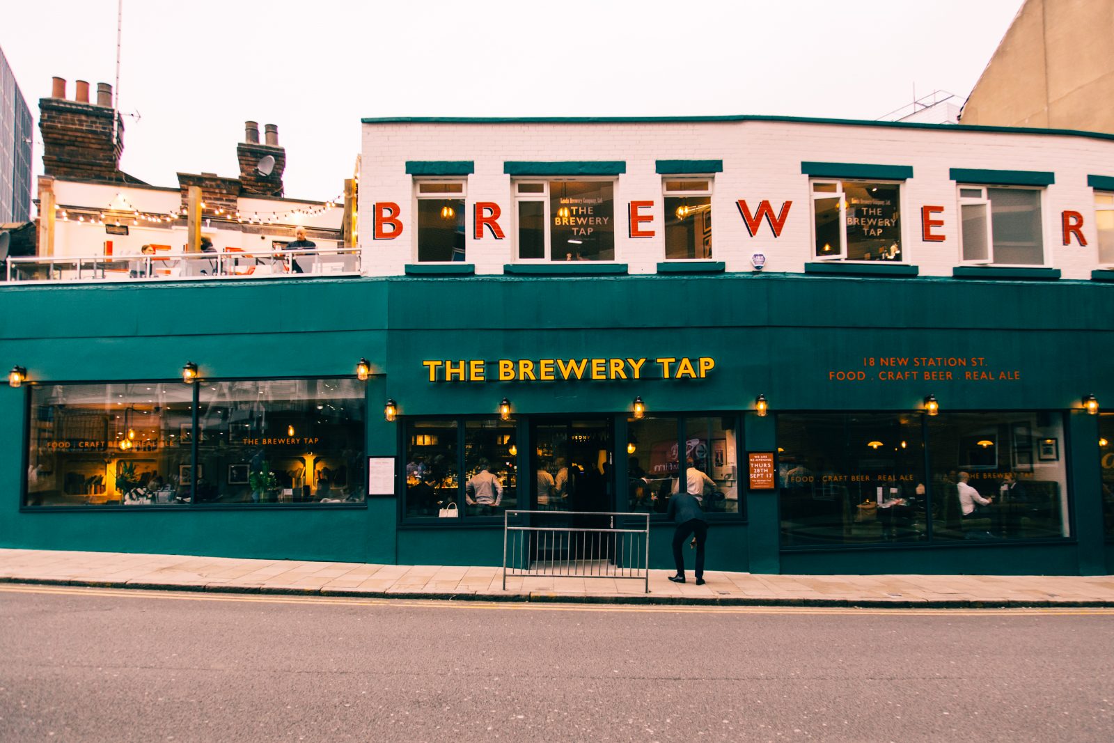 outside of bar with sign 'The Brewery Tap' in yellow letters.