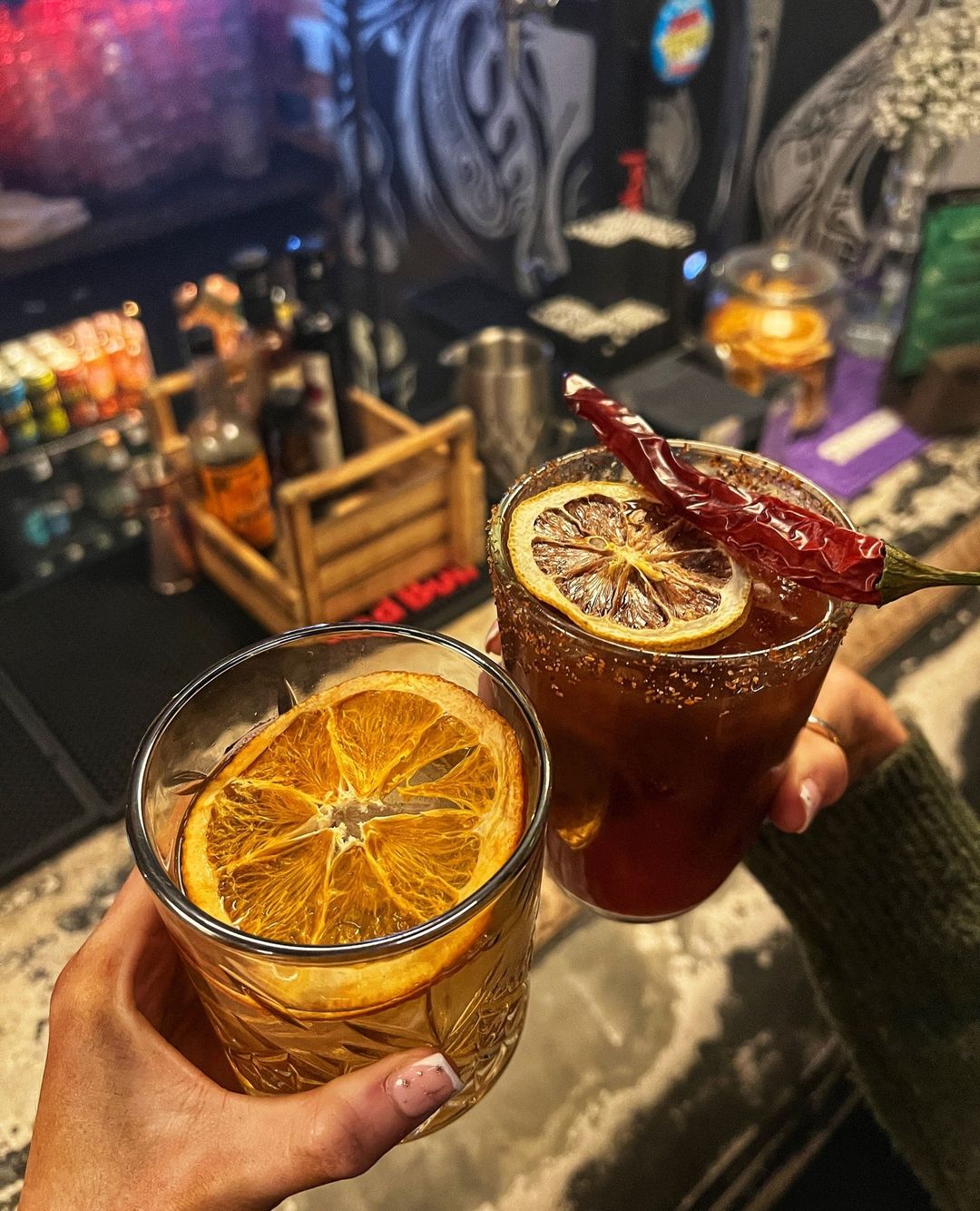 two cocktails with oranges in them.
