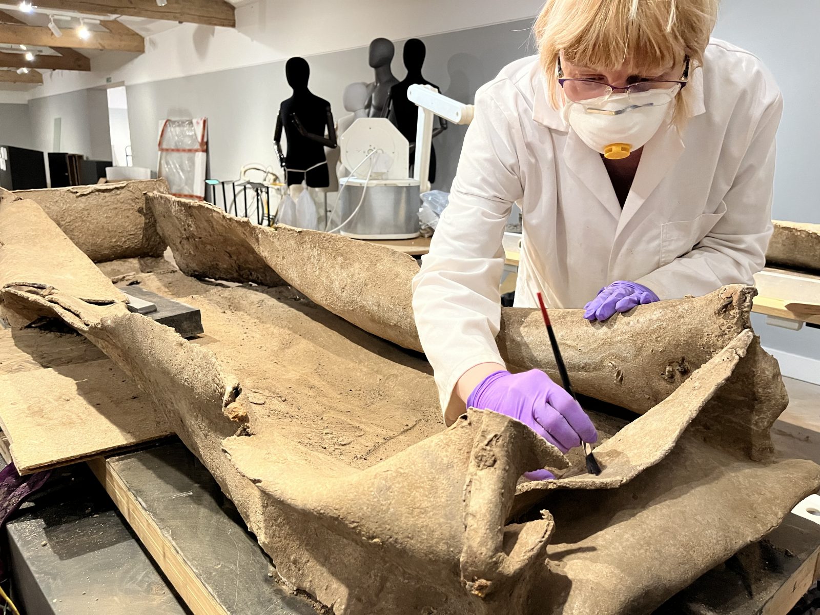 A lady working on an ancient coffin found in Leeds. 
