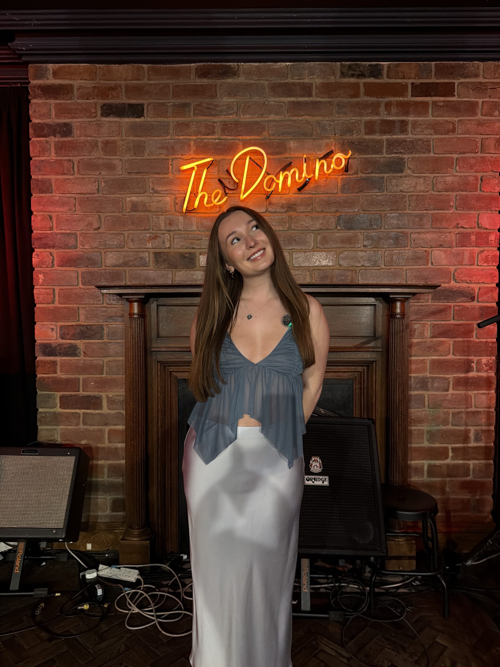 Rolfe backstage ahead of her Piece Hall supporting slot and the singer pictured underneath The Domino Club neon sign / Credit: Supplied